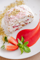 beautiful tasty green vegan dessert pistachio strawberry rolls on a wooden table in the interior.