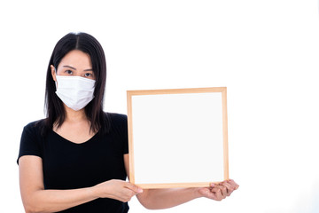 An Asian woman wearing a white mask and holding an empty board for writing COVID-19 prevention isolated on white background.