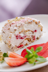 beautiful tasty green vegan dessert pistachio strawberry rolls on a wooden table in the interior.