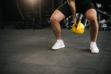 Strong muscular man with perfect beautiful body wearing sportswear lifting heavy free weights...