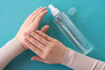 Top view of young girls hands using spray bottle with antiseptic liquid. Concept of health care,...