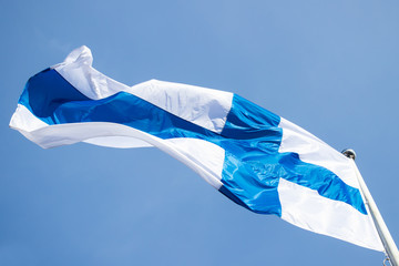 Finnish national flag on the wind against the blue sky