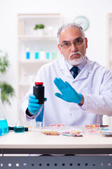 Fototapeta premium Old male chemist working in the lab