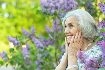 Happy senior beautiful woman on lilacs background