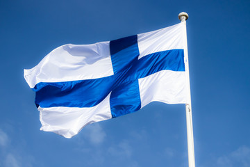 Finnish national flag on the wind against the blue sky