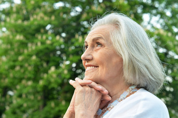 Fototapeta premium Portrait of senior beautiful smiling woman posing in spring park