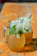 two mugs with mojito on wooden table