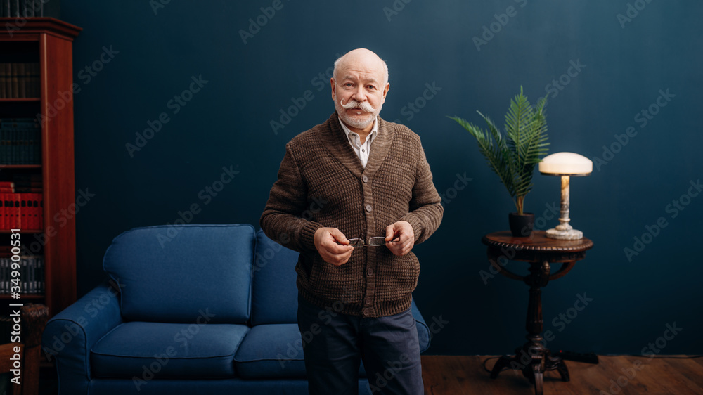 Wall mural representative elderly man poses in home office