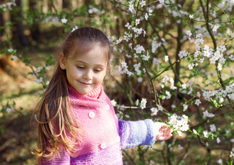 portrait of a little girl in a flowered garden