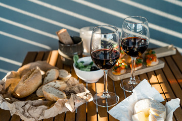 Glasses of red wine at dining table in backyard patio