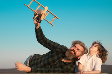 Father and son. Child pilot aviator with airplane dreams of traveling. Parent with child boy. Father playing with kid.