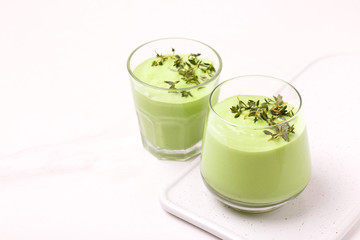 green smoothie with avocado, cucumber, celery and thyme.