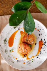 mashed potatoes with cutlet, on a beautiful white plate. The dish is decorated with micro-greens. Against the background of a wooden table in the interior.