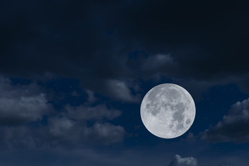 Fototapeta na wymiar Full moon and blurred dark clouds on the sky.