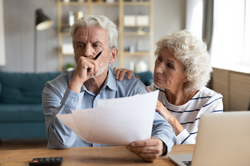 Compassionate elderly woman supporting upset stressed mature husband, received bad news banking...