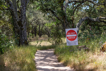 The  stop sign at the entrance to the green summer county park, follow one-way routes to promote social distancing.
