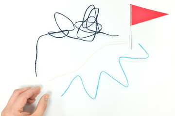 Reaching goal in own path and pace concept. Yarn of different lenght and a red flag.