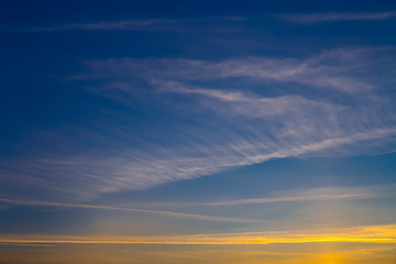 Fototapeta premium magical sunset, beautiful light from the sun, the trace of an airplane in the sky, colored lines in the sky, Cirrus clouds