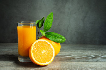 Glass of Fresh Orange Juice Fruit Extract and Slice Orange on Wooden Table