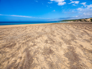 Fototapeta na wymiar The immense and wonderful beach of Piscinas with its exotic panorama, near imposing and sinuous dunes of fine, warm golden sand