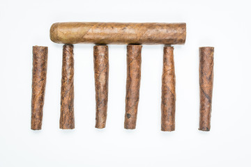 Big and small cigars twisted from sheets of tobacco on white background.