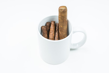 Brown cigars from twisted sheets in mug with white background.