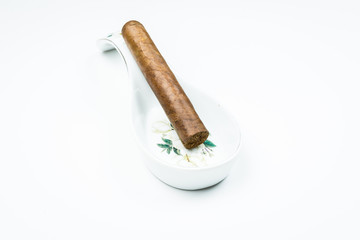 Gorgeous cigar from twisted sheets in the stand for the cook with white background.