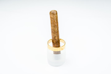 Excellent cigars from twisted sheets in glass pile with white background.