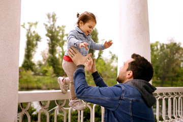 Father and daughter are walking in the park, a family of two, a child having fun with dad