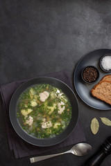 Chicken and potato chowder soup with pepper and carrot in black bowl