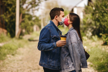 Fototapeta premium Guy and girl kiss in protective masks, antiviral protection during the coronavirus pandemic