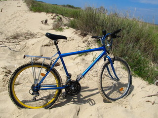Blue tourist bike on the sand.