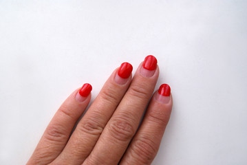Overgrown manicure. Red gel-polish on half of the nail. Lockdown-nail salons are closed. Unkempt hands.