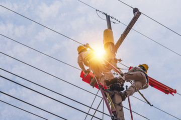 Two linesmen use insulated equipment to repair and maintain high-voltage distribution systems. The...
