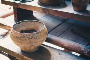 Cast iron pot for cooking on wooden bench.