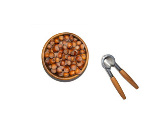 Picture of a bowl full of hazelnuts with nuts cracker isolated on white.