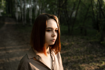 Naklejka premium portrait of a girl in the forest with brown hair