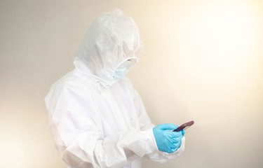 Fototapeta premium Doctor is wearing PPE suit and looking for corona/covid-19 virus infected patient's laboratory on application phone report , For protection Coronavirus (COVID19) epidemic