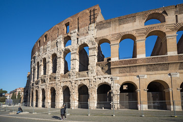Obraz premium Tourists visit Colosseum ruins in Rome. It is the greatest roman building in the world.