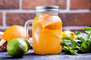 Cold citrus fruit lemonade in jar with orange , lime and lemon
