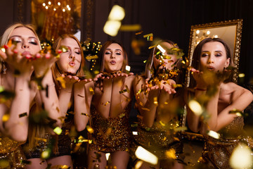 Fun party at girls, bachelorette party. New Year's party in the studio, dark background and gold...