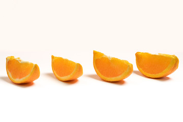 Fototapeta na wymiar Four fresh orange segments placed in parallel with white background