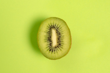 Isolated half fresh kiwi with green background