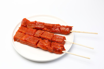 Pincho o brocheta de carne cruda aliñada en un plato con fondo blanco