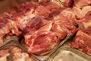 Fresh raw pork meat lies on the counter. A wide range of pork in a butcher's shop. An abundance of beautiful red raw pork meat.
