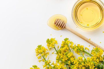 A bowl of honey with surepka flowers on a white background
