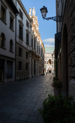 Vicenza, in the afternoon the street called Contra del Monte is completely in the shade, while the Palladian Basilica is illuminated. This condition creates an interesting depth effect. Italy.