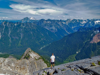 Fototapeta premium Hiker at the edge of admiring mountains
