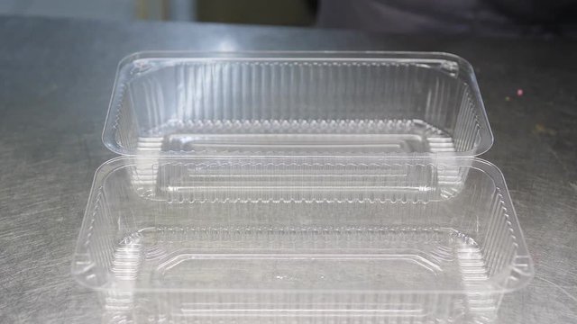 Food delivery in the restaurant. The chef prepares food in the restaurant and packs it in disposable dishes