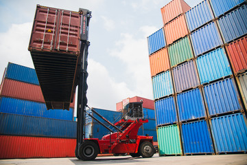 Container forklift working to stack the Container which help to control loading freight logistic at commercial shipping dock. Cargo freight ship import